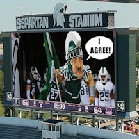 the michigan state spartans logo on a large screen at spartan stadium