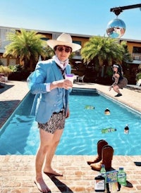 a man in a suit standing next to a pool