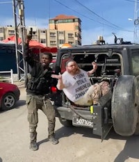 two men standing in front of a jeep