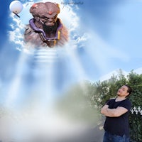 a man standing with his arms crossed in front of an image of an alien