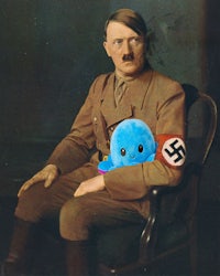 a man sitting in a chair holding a blue stuffed animal