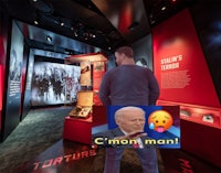 a man is standing in front of a display of weapons