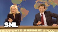 a man and woman sitting at a table with the words snl update june update