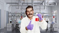 a man in a lab giving a thumbs up